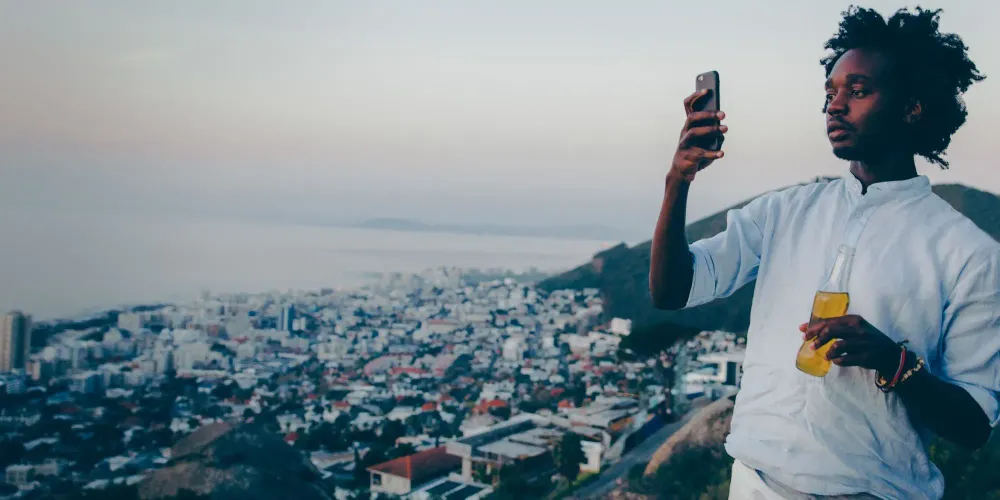 man taking smartphone photo of city